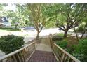 View from the porch shows the landscaped yard and quiet street with mature trees in the neighborhood at 4704 Beech Crest Pl, Charlotte, NC 28269