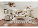 Spacious, neutral living room featuring hardwood floors, decorative ceiling fans and modern furnishings at 5303 Rogers Rd, Monroe, NC 28110