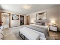 Serene main bedroom with soft carpet, neutral tones, and a decorative seating bench at 5303 Rogers Rd, Monroe, NC 28110
