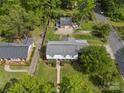 Spacious property showcases a neatly maintained lawn, auxiliary garage, and a classic two-story house from a birds-eye perspective at 6035 Idlebrook Dr, Charlotte, NC 28212