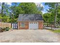 Detached brick garage with white doors and a paved driveway, offering ample parking and storage space at 6035 Idlebrook Dr, Charlotte, NC 28212