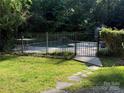 Fenced in pool area, landscaped with grassy area and stone walkway at 729 Lochaven Rd, Waxhaw, NC 28173