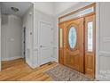 Bright foyer featuring hardwood floors, a decorative front door, and white trim at 7815 Scottsburg Ct, Mint Hill, NC 28227