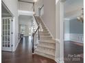 Elegant foyer with hardwood floors, staircase, and views into the living and dining areas at 8014 Avanti Dr, Marvin, NC 28173