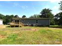 View of the back of the house featuring a small wood deck and grassy yard at 828 Long Bow Rd, Salisbury, NC 28144