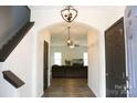 Bright entryway featuring hardwood floors, an archway, a pendant light, and an open living area at 8820 First Run Ct, Charlotte, NC 28215