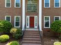 Close up of the front door with stairs leading up to the house, and landscaping to either side at 9000 Stourbridge Dr, Huntersville, NC 28078