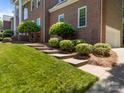 Landscaped front yard with green lawn and various shrubbery and concrete stairs leading up to the house at 9000 Stourbridge Dr, Huntersville, NC 28078