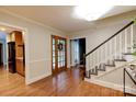 Welcoming foyer featuring wood floors, a staircase, and a charming entry door at 9439 White Hemlock Ln, Charlotte, NC 28270
