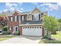 Charming two-story brick home featuring a two-car garage and professionally landscaped front yard at 9803 Forest Run Ln, Charlotte, NC 28277