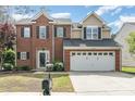 Charming two-story brick home featuring a two-car garage and professionally landscaped front yard at 9803 Forest Run Ln, Charlotte, NC 28277