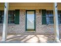 Close-up of the front entrance featuring a brick facade, a glass door and sidelight with green trim at 1 Horace Grigg Cir, Shelby, NC 28152