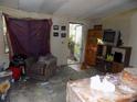 Living room featuring an armchair, doorway to porch, TV stand, and window at 107 N Rudisill Ave, Cherryville, NC 28021