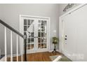 Bright foyer with hardwood floors, white trim, glass panel doors, and stairs at 111 Woodfern Pl, Mooresville, NC 28115
