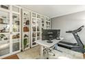 Bright home office with glass cabinets, desk, treadmill and neutral color palette at 111 Woodfern Pl, Mooresville, NC 28115