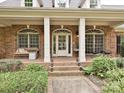 Inviting front porch with ample seating, brick columns, and decorative details for relaxing outdoors at 1126 Concord Rd, Davidson, NC 28036