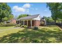 Spacious brick home featuring a well-manicured lawn and a welcoming covered porch at 113 S College St, Monroe, NC 28112