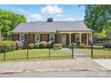 Charming brick home with a well-maintained front lawn and gated front yard at 113 S College St, Monroe, NC 28112