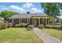 Charming brick home with a well-maintained front lawn and covered porch, exuding curb appeal at 113 S College St, Monroe, NC 28112
