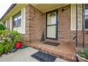 Inviting brick front porch features a black trimmed storm door, tile steps, and charming welcome mat at 1222 Glenarden Dr, Rock Hill, SC 29730