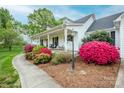 Inviting front porch with seating and colorful landscaping enhances the curb appeal of this beautiful home at 123 Coachman Loop, Statesville, NC 28625