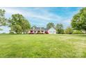 Expansive front yard leading to a charming white home featuring an inviting porch and attached two-car garage at 123 Coachman Loop, Statesville, NC 28625