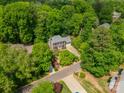 Aerial shot of a beautiful brick home surrounded by lush, mature trees in a residential neighborhood at 14926 Chilgrove Ln, Huntersville, NC 28078