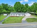 An aerial view of a well-maintained home with a detached garage and carport, surrounded by lush greenery at 1981 Line Rd, Lancaster, SC 29720