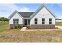A daytime view of a charming single-story home featuring white siding and a brick foundation at 210 Goldenrod Cir, Salisbury, NC 28147