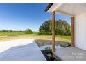 Welcoming covered front porch with wood columns and a concrete walkway, offering a charming entrance to the home at 240 Doster Rd, Lancaster, SC 29720