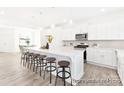 Bright kitchen featuring a large center island with seating, modern appliances, white cabinets, and hardwood floors at 2416 Morgan Hills Dr # 297P, Albemarle, NC 28001