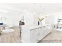 Well-lit open concept kitchen with a large island, hardwood floors, stainless appliances and views into the dining and living area at 2416 Morgan Hills Dr # 297P, Albemarle, NC 28001