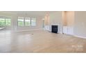 Bright, open-concept living room with elegant fireplace, mantle, and large windows offering scenic views at 2806 Morning Song Way, Lancaster, SC 29720