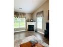 Cozy fireplace with decorative mantle and a large window providing natural light at 4223 Willow View Ct, Matthews, NC 28105