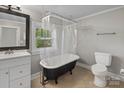 Bathroom featuring a clawfoot tub with shower, vanity, toilet, and window at 510 S Carolina Ave, Spencer, NC 28159
