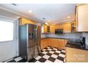 This updated kitchen showcases stainless steel appliances, custom cabinetry, and checkerboard floors at 539 Marsh Rd, Charlotte, NC 28209