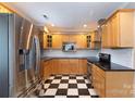 This updated kitchen showcases stainless steel appliances, custom cabinetry, and checkerboard floors at 539 Marsh Rd, Charlotte, NC 28209
