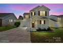 Beautiful two-story home with red shutters and a covered porch, captured against a vibrant twilight sky at 6135 Raisin Tree Ln, Charlotte, NC 28215