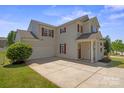 Spacious two-story home featuring a two-car garage, covered front porch, and well-manicured lawn at 6135 Raisin Tree Ln, Charlotte, NC 28215