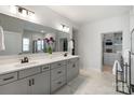 Modern bathroom with double vanity, sleek fixtures, and a walk-in closet, enhanced by marble tile flooring at 6145 Holland St, Fort Mill, SC 29707