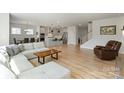 Spacious open-concept living area flowing into the kitchen, featuring a comfortable sofa and hardwood flooring at 6145 Holland St, Fort Mill, SC 29707