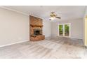Cozy living room featuring a brick fireplace, carpet flooring, and natural light through glass doors at 6769 Highway 557 None, Clover, SC 29710