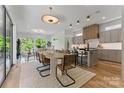 Open-concept dining area with a unique light fixture, seamlessly connected to the kitchen and living room at 721 Charles Ave, Charlotte, NC 28205