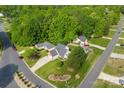 Aerial view highlighting a well-maintained lawn, mature trees, and the location of this property within the neighborhood at 7239 Oxford Hunt Dr, Stanley, NC 28164