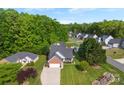 An aerial shot showcases the home's landscaping, large yard, and position in a tranquil residential community at 7239 Oxford Hunt Dr, Stanley, NC 28164
