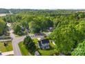 This aerial view shows the home situated on a verdant lot with mature trees, providing privacy and charm at 7239 Oxford Hunt Dr, Stanley, NC 28164