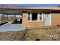 Welcoming brick home with light blue door and covered carport, enhancing curb appeal at 7527 Old Shelby Rd, Vale, NC 28168