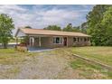 Charming single-story brick home with a metal roof, covered carport, and well-maintained front yard at 7527 Old Shelby Rd, Vale, NC 28168