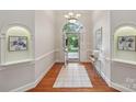 Elegant foyer with hardwood floors, arched details, transom window and open doorway to the front yard at 7626 Vistaview Dr, Cornelius, NC 28031