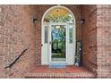Close-up of a welcoming front door with a charming arched window, brick surround, and welcome sign at 7626 Vistaview Dr, Cornelius, NC 28031